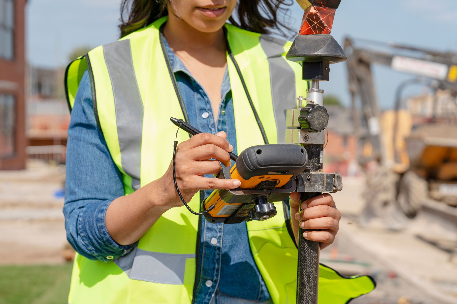 Confident Female Building Surveyor using surveying instrument to conducting measurements at  construction site